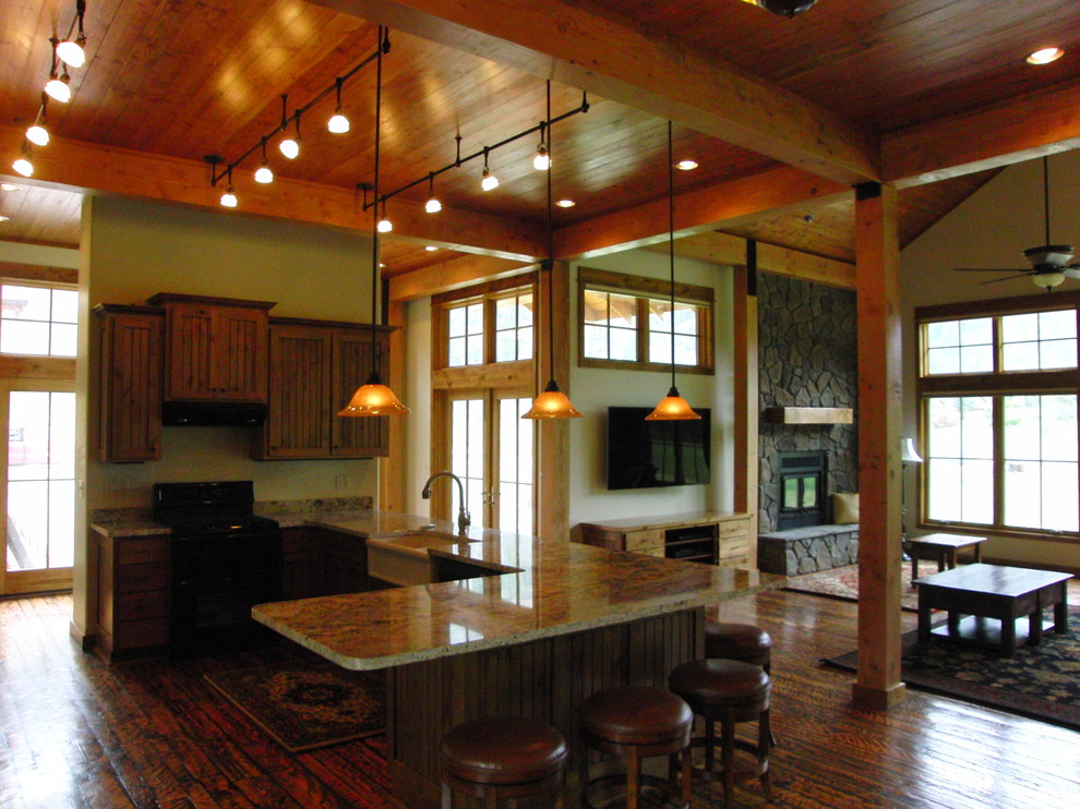 Photo of a large rustic kitchen/diner in Tampa with a belfast sink, beaded cabinets, medium wood cabinets, granite worktops, black appliances, medium hardwood flooring and no island.