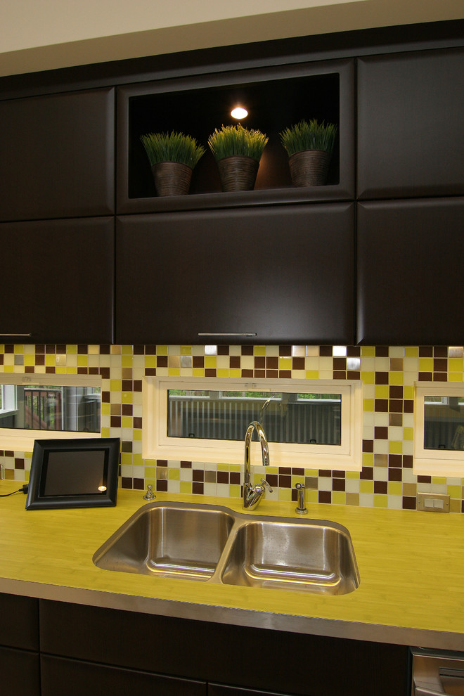 Foto di una cucina minimal di medie dimensioni con lavello sottopiano, ante lisce, ante in legno bruno, top in laminato, paraspruzzi multicolore, paraspruzzi con piastrelle a mosaico, elettrodomestici in acciaio inossidabile e pavimento in bambù