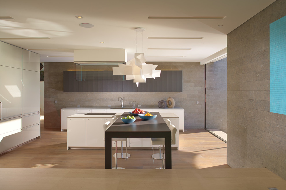 Modelo de cocina comedor contemporánea con armarios con paneles lisos, puertas de armario blancas y electrodomésticos con paneles
