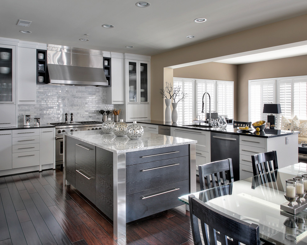 Large contemporary grey and white u-shaped kitchen/diner in DC Metro with stainless steel appliances, a submerged sink, shaker cabinets, white cabinets, marble worktops, white splashback, dark hardwood flooring, an island and marble splashback.