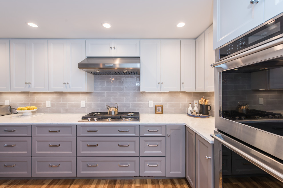 Mid-sized trendy l-shaped medium tone wood floor and brown floor eat-in kitchen photo in DC Metro with an undermount sink, recessed-panel cabinets, gray cabinets, quartz countertops, beige backsplash, subway tile backsplash, stainless steel appliances and an island