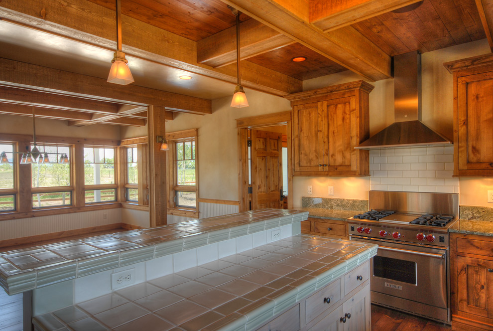 Bild på ett mellanstort lantligt kök, med en rustik diskho, skåp i shakerstil, skåp i mellenmörkt trä, granitbänkskiva, rostfria vitvaror, mellanmörkt trägolv, en köksö och brunt golv