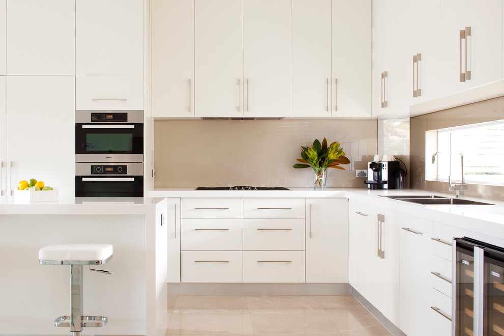 Design ideas for a contemporary l-shaped kitchen/diner in Sydney with a double-bowl sink, engineered stone countertops, beige splashback and an island.
