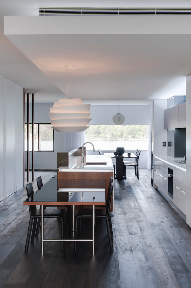 Medium sized contemporary galley kitchen/diner in Sydney with a double-bowl sink, white cabinets, composite countertops, stainless steel appliances, dark hardwood flooring and an island.