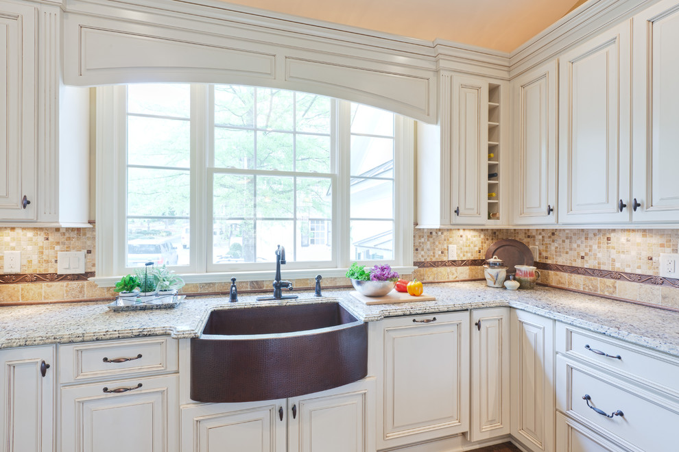 Inspiration for a large timeless u-shaped medium tone wood floor and brown floor eat-in kitchen remodel in Atlanta with raised-panel cabinets, a farmhouse sink, white cabinets, granite countertops, multicolored backsplash, travertine backsplash, stainless steel appliances, a peninsula and beige countertops