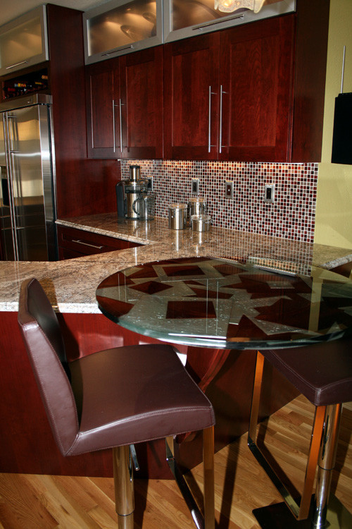 Example of a mid-sized minimalist u-shaped medium tone wood floor eat-in kitchen design in Denver with an undermount sink, shaker cabinets, dark wood cabinets, glass countertops, red backsplash, glass sheet backsplash, stainless steel appliances and a peninsula