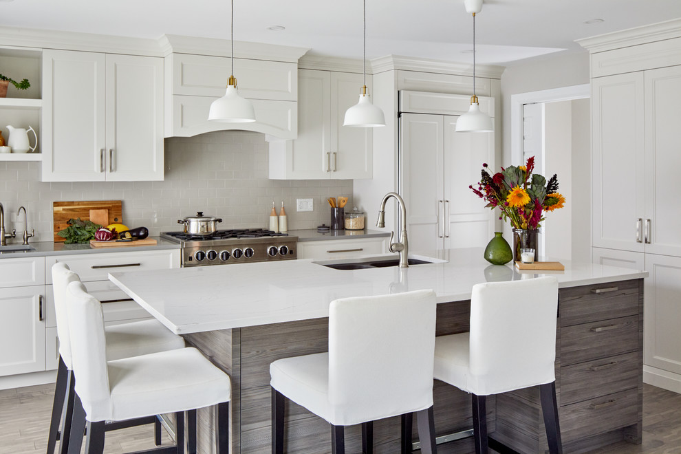 Foto på ett mellanstort funkis vit kök, med en dubbel diskho, vita skåp, bänkskiva i kvarts, grått stänkskydd, stänkskydd i keramik, integrerade vitvaror, en köksö, luckor med infälld panel och grått golv