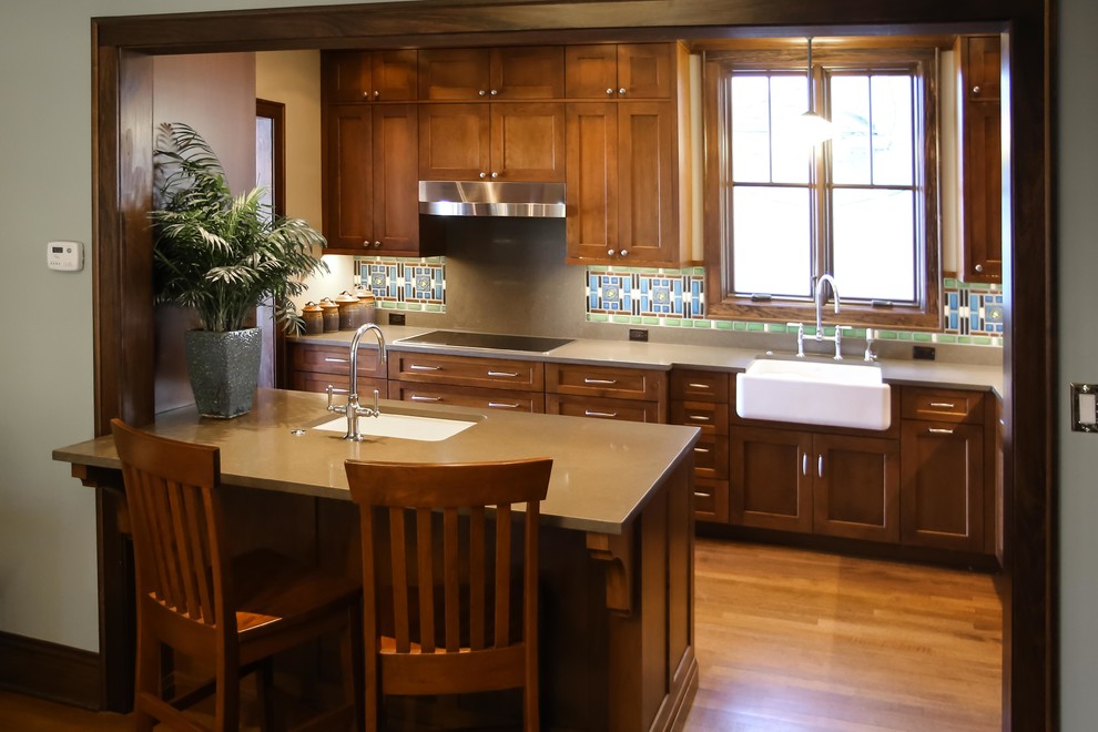 Exempel på ett amerikanskt kök, med en rustik diskho, skåp i shakerstil, skåp i mellenmörkt trä, flerfärgad stänkskydd, rostfria vitvaror, ljust trägolv, en halv köksö, bänkskiva i täljsten och stänkskydd i keramik