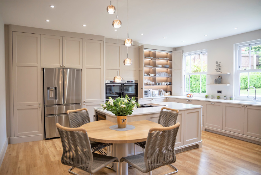 Example of a huge transitional l-shaped medium tone wood floor and brown floor eat-in kitchen design in Other with an undermount sink, shaker cabinets, gray cabinets, stainless steel appliances, an island and white countertops