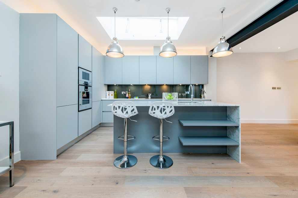 ロンドンにあるコンテンポラリースタイルのおしゃれなキッチン (フラットパネル扉のキャビネット、青いキャビネット、無垢フローリング) の写真