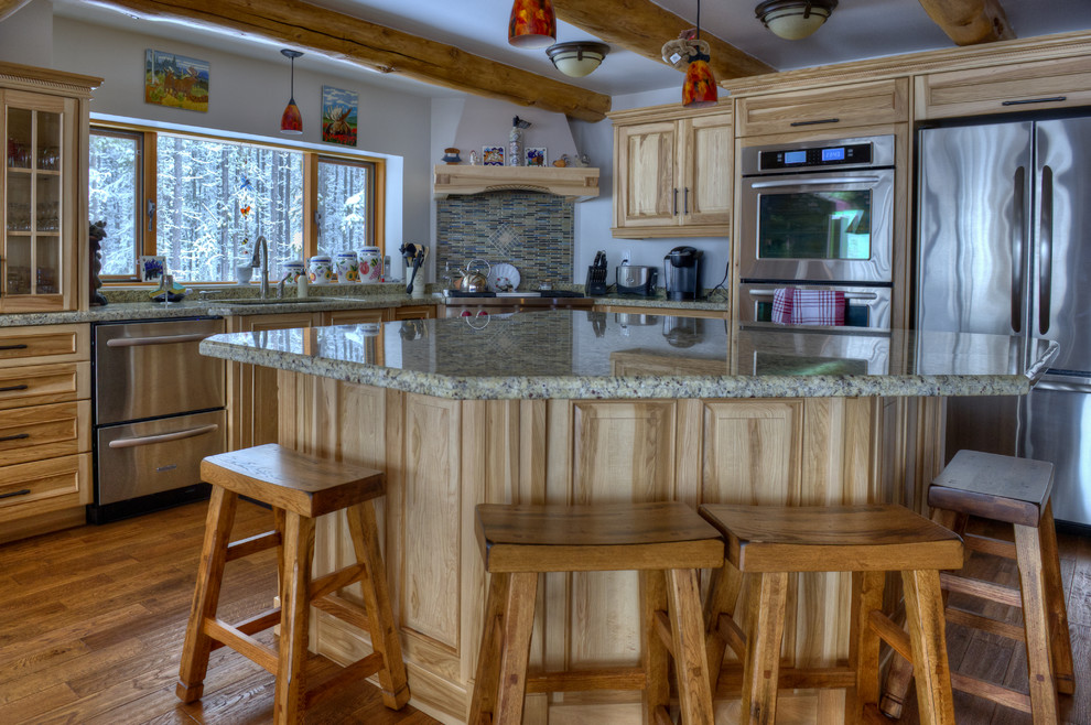 Inspiration for a large rustic l-shaped medium tone wood floor and brown floor kitchen remodel in Vancouver with a single-bowl sink, recessed-panel cabinets, light wood cabinets, granite countertops, multicolored backsplash, matchstick tile backsplash, stainless steel appliances and an island