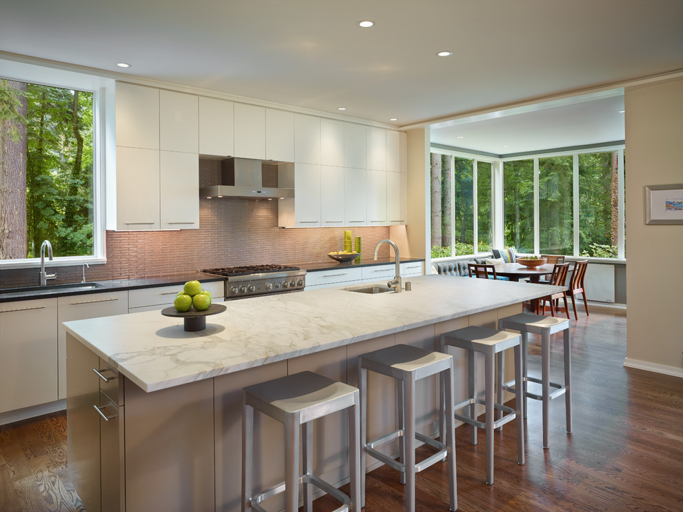 Trendy eat-in kitchen photo in Seattle with an undermount sink, flat-panel cabinets, white cabinets, marble countertops and matchstick tile backsplash