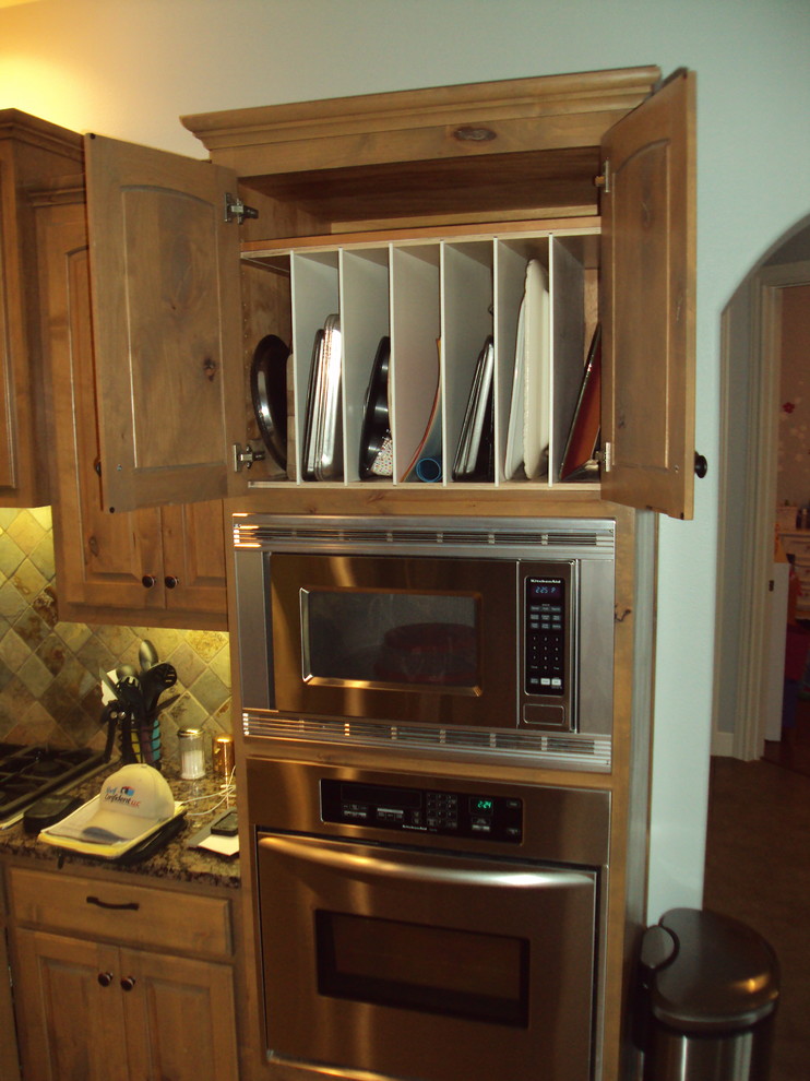 Foto på ett mellanstort vintage kök med öppen planlösning, med luckor med upphöjd panel, skåp i slitet trä, granitbänkskiva, flerfärgad stänkskydd, stänkskydd i sten, rostfria vitvaror och travertin golv