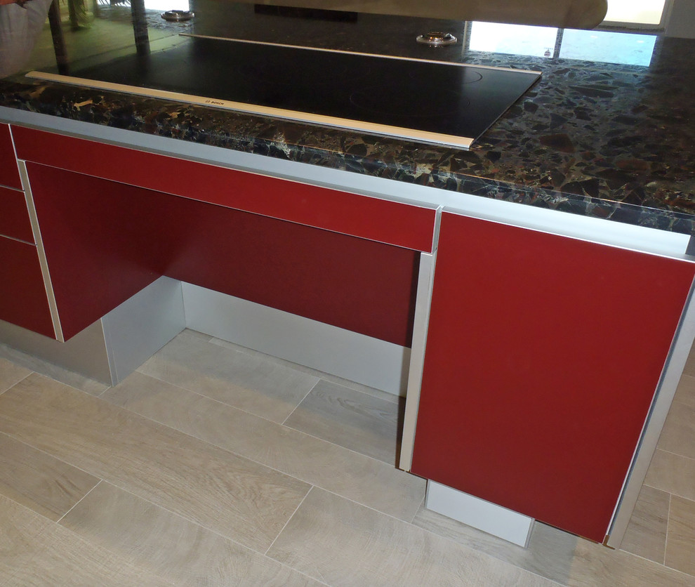 Inspiration for a contemporary l-shaped kitchen/diner in Hawaii with a submerged sink, flat-panel cabinets, red cabinets, marble worktops, metallic splashback, porcelain splashback and stainless steel appliances.