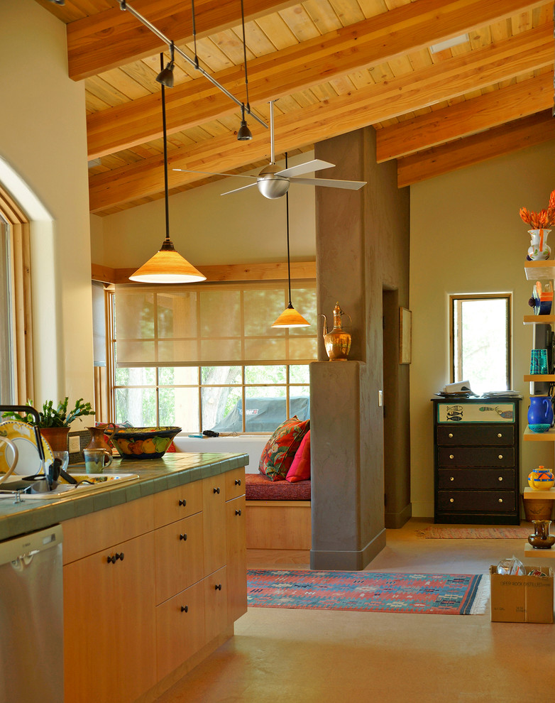 Идея дизайна: угловая кухня-гостиная среднего размера в стиле фьюжн с плоскими фасадами, светлыми деревянными фасадами, столешницей из плитки, бетонным полом и островом