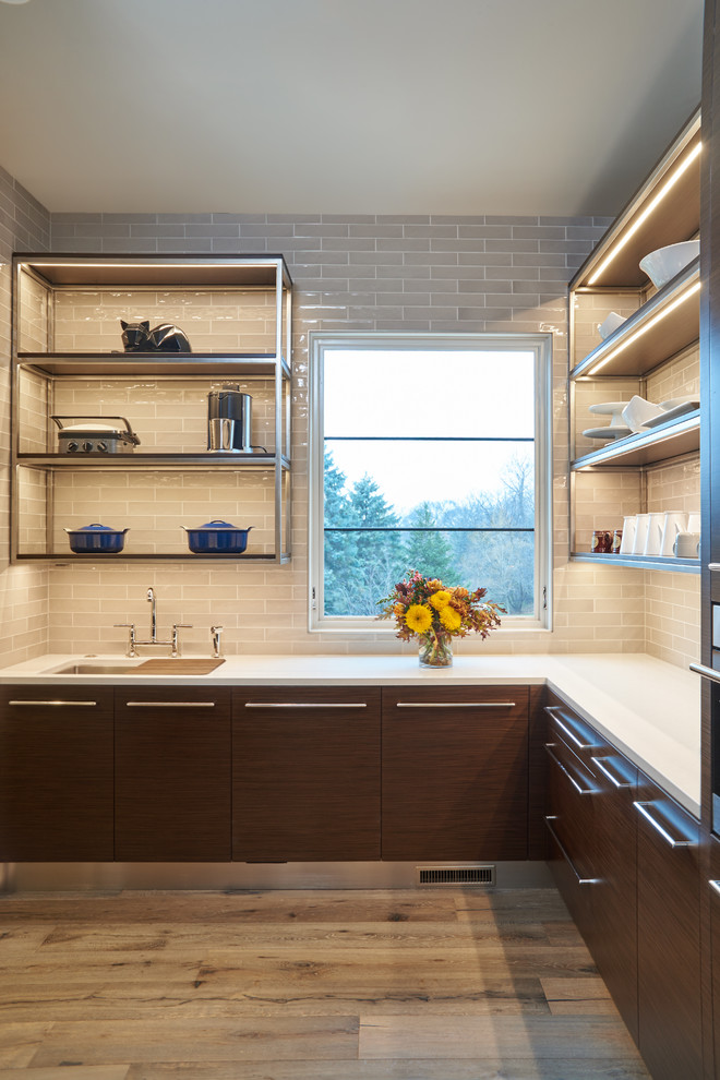 Inspiration for a large contemporary l-shaped medium tone wood floor and gray floor kitchen pantry remodel in Minneapolis with a single-bowl sink, flat-panel cabinets, dark wood cabinets, quartz countertops, white backsplash, subway tile backsplash, stainless steel appliances and no island