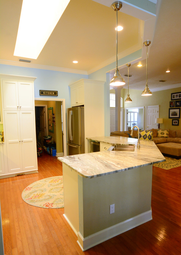 Exempel på ett mellanstort kök, med en rustik diskho, vita skåp, granitbänkskiva, rostfria vitvaror och en halv köksö
