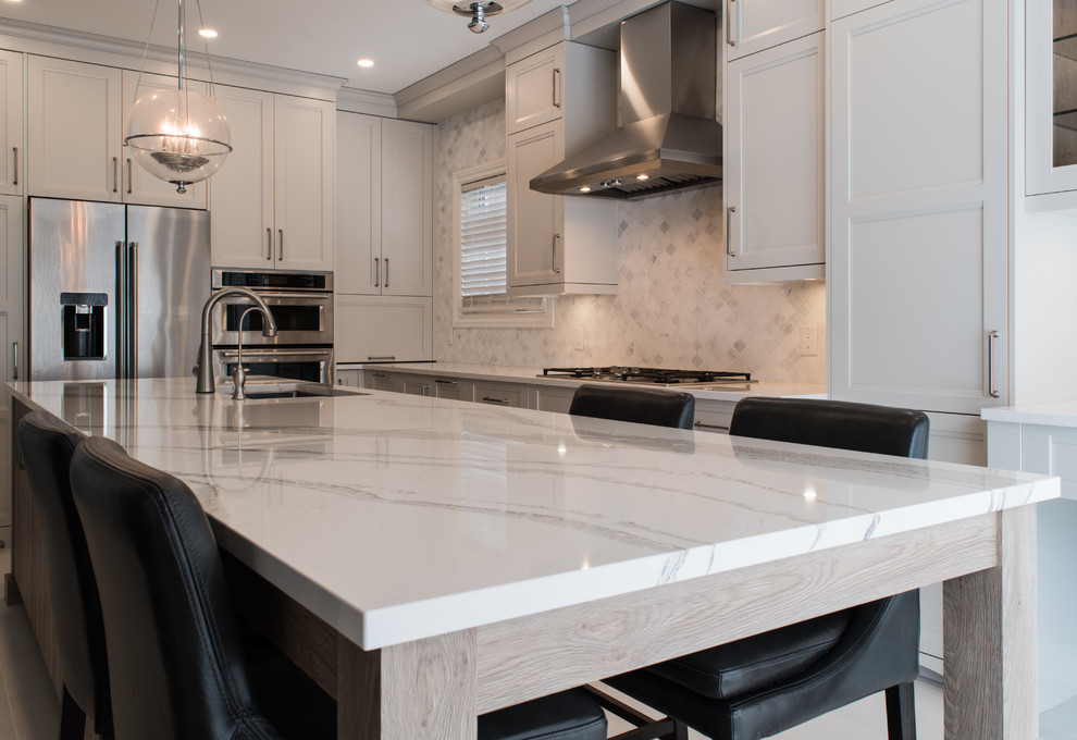 Large transitional l-shaped porcelain tile and beige floor eat-in kitchen photo in Toronto with an undermount sink, shaker cabinets, gray cabinets, quartz countertops, white backsplash, marble backsplash, stainless steel appliances, an island and white countertops
