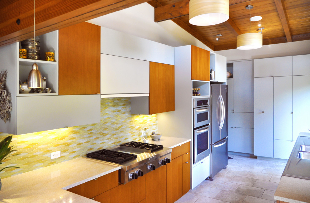 中くらいなミッドセンチュリースタイルのおしゃれなキッチン (ダブルシンク、フラットパネル扉のキャビネット、グレーのキャビネット、クオーツストーンカウンター、黄色いキッチンパネル、セラミックタイルのキッチンパネル、シルバーの調理設備、セラミックタイルの床) の写真
