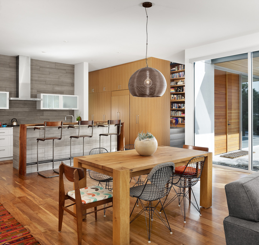 Trendy galley open concept kitchen photo in Austin with glass-front cabinets, white cabinets and gray backsplash