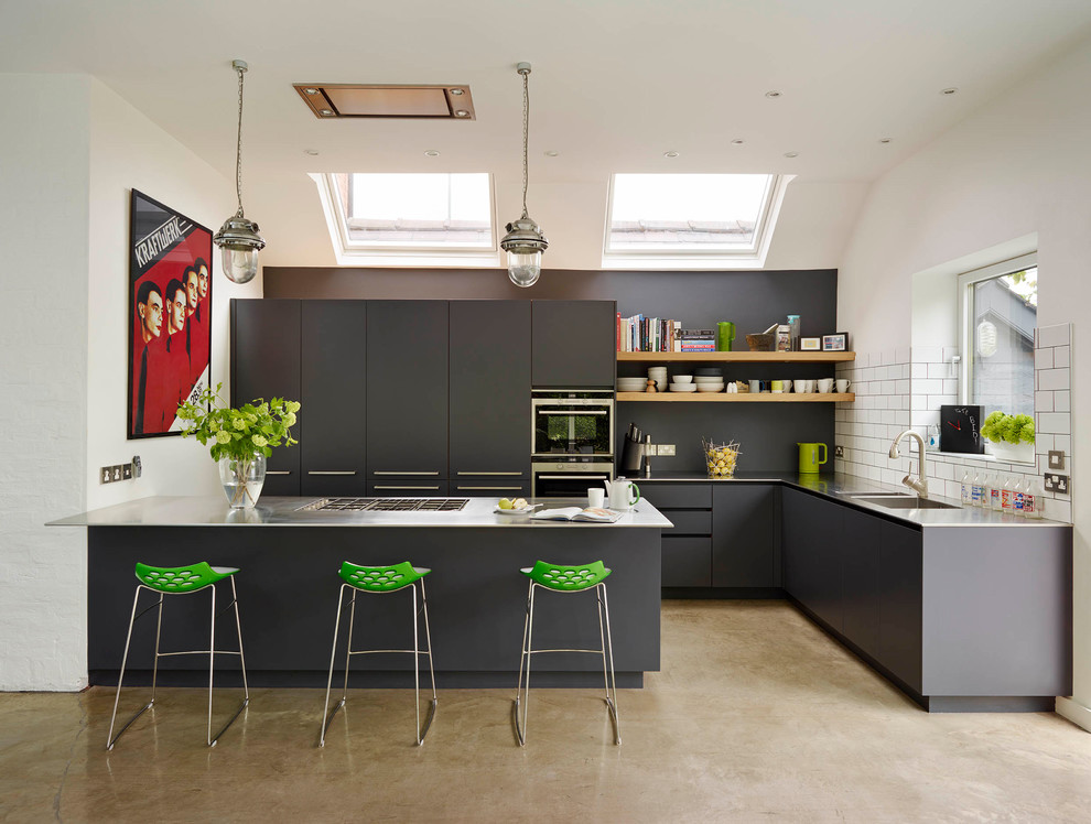 Exempel på ett stort modernt kök, med en integrerad diskho, släta luckor, svarta skåp, bänkskiva i rostfritt stål, vitt stänkskydd, stänkskydd i keramik, betonggolv och beiget golv
