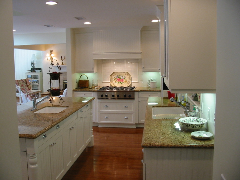 Design ideas for a large traditional kitchen in Los Angeles with a submerged sink, shaker cabinets, white cabinets, granite worktops, white splashback, ceramic splashback, stainless steel appliances, medium hardwood flooring and an island.