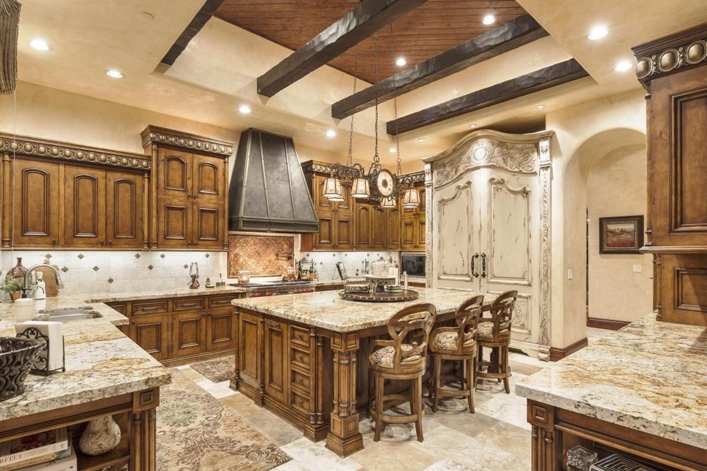 Inspiration for a large mediterranean u-shaped travertine floor eat-in kitchen remodel in Phoenix with a double-bowl sink, recessed-panel cabinets, dark wood cabinets, recycled glass countertops, white backsplash, porcelain backsplash, stainless steel appliances and an island