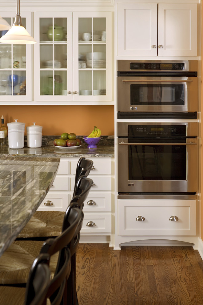 Exempel på ett mellanstort klassiskt kök, med en rustik diskho, skåp i shakerstil, vita skåp, granitbänkskiva, rostfria vitvaror, mörkt trägolv och en köksö