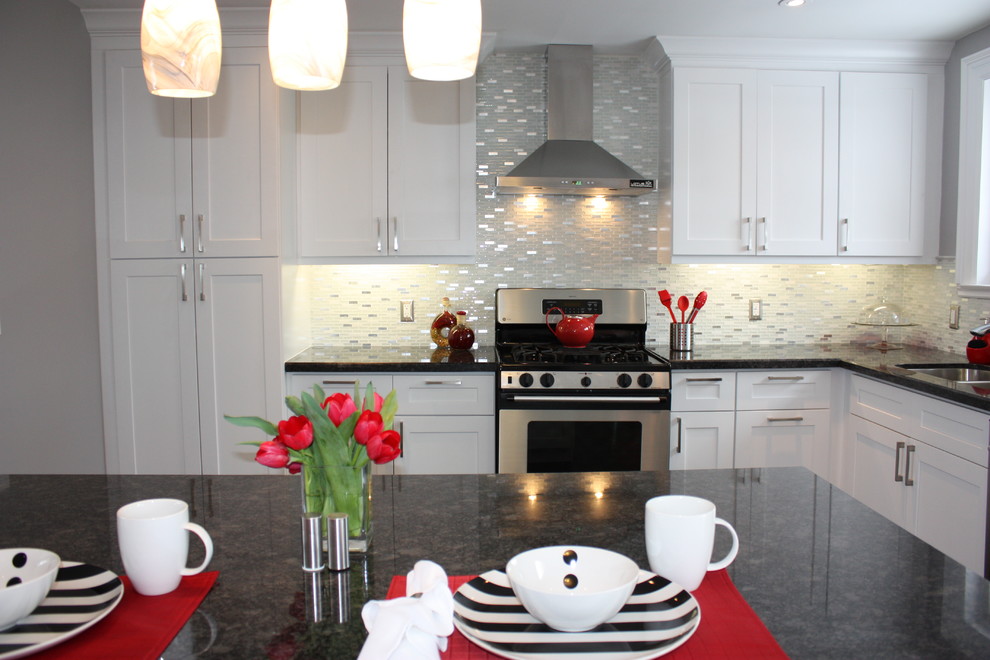This is an example of a medium sized modern l-shaped kitchen/diner in Toronto with a submerged sink, shaker cabinets, white cabinets, granite worktops, white splashback, mosaic tiled splashback, stainless steel appliances, dark hardwood flooring and an island.