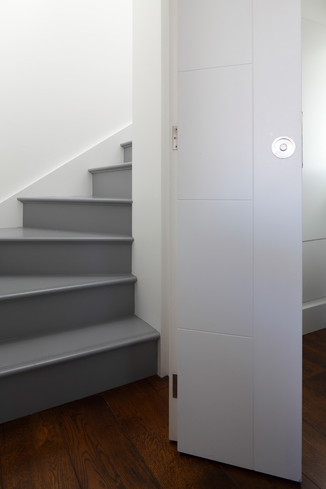 Cette image montre un grand escalier design avec des marches en bois et des contremarches en bois.