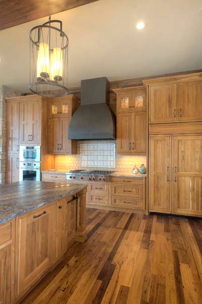 Urige Küche mit Granit-Arbeitsplatte, Küchengeräten aus Edelstahl und Kücheninsel in Sonstige