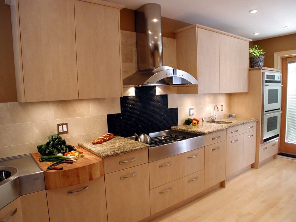 This is an example of a small contemporary single-wall enclosed kitchen in Other with a double-bowl sink, flat-panel cabinets, light wood cabinets, granite worktops, beige splashback, porcelain splashback, stainless steel appliances, light hardwood flooring and no island.