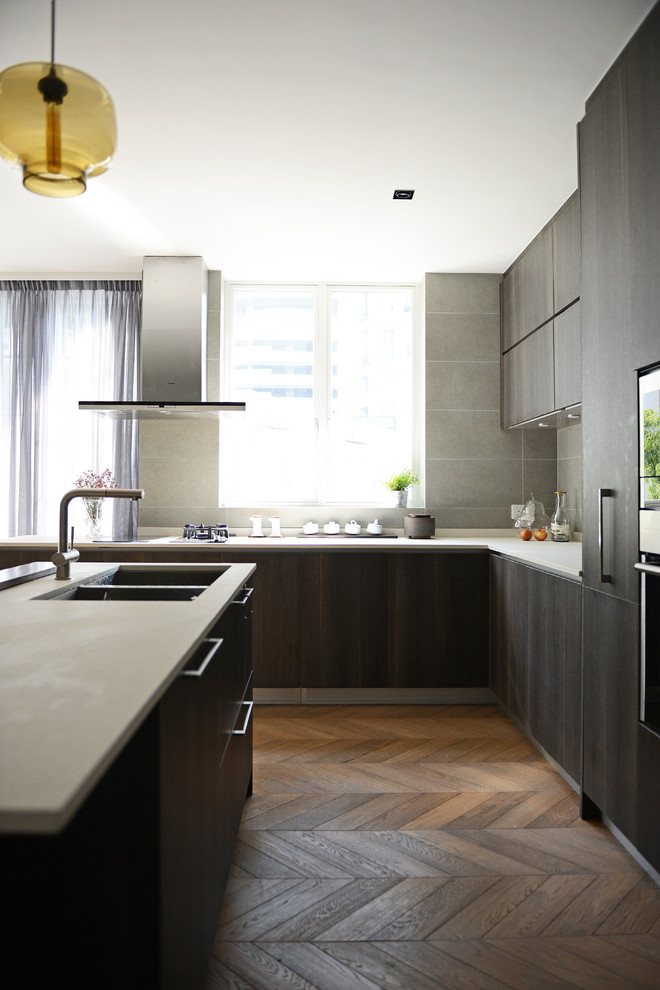 Exempel på ett modernt kök, med en undermonterad diskho, släta luckor, skåp i mörkt trä, grått stänkskydd och rostfria vitvaror