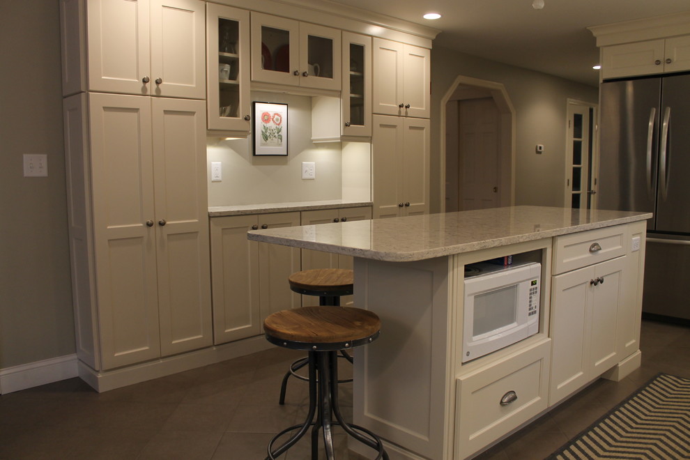 Example of a large classic l-shaped ceramic tile eat-in kitchen design in Boston with an undermount sink, recessed-panel cabinets, white cabinets, granite countertops, white backsplash, subway tile backsplash, stainless steel appliances and an island