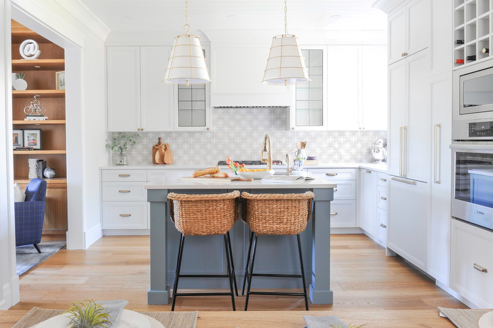 Inspiration for a large transitional l-shaped medium tone wood floor and shiplap ceiling eat-in kitchen remodel in Vancouver with recessed-panel cabinets, white cabinets, paneled appliances, an island, white countertops, an undermount sink, quartz countertops, beige backsplash and porcelain backsplash