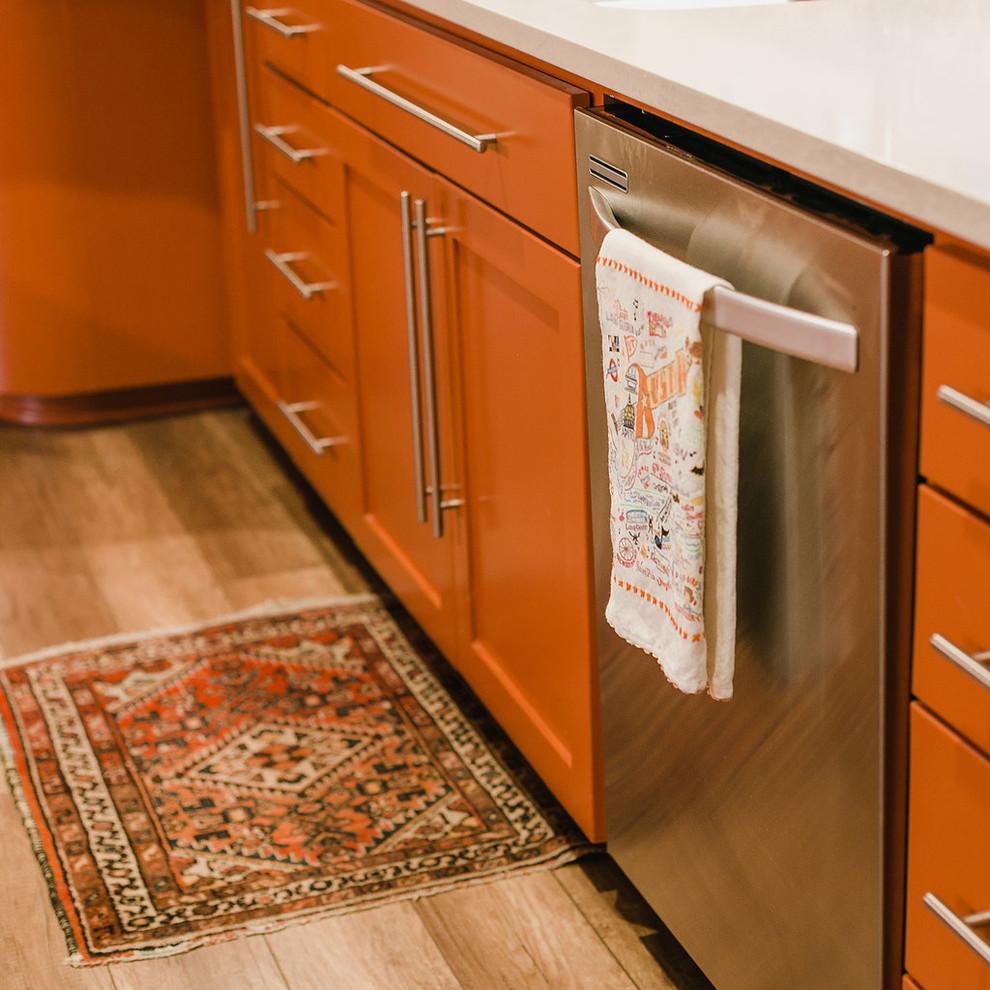 Stilmix Küche mit Doppelwaschbecken, orangefarbenen Schränken, Quarzwerkstein-Arbeitsplatte, bunter Rückwand, Rückwand aus Terrakottafliesen, Küchengeräten aus Edelstahl und weißer Arbeitsplatte in Austin