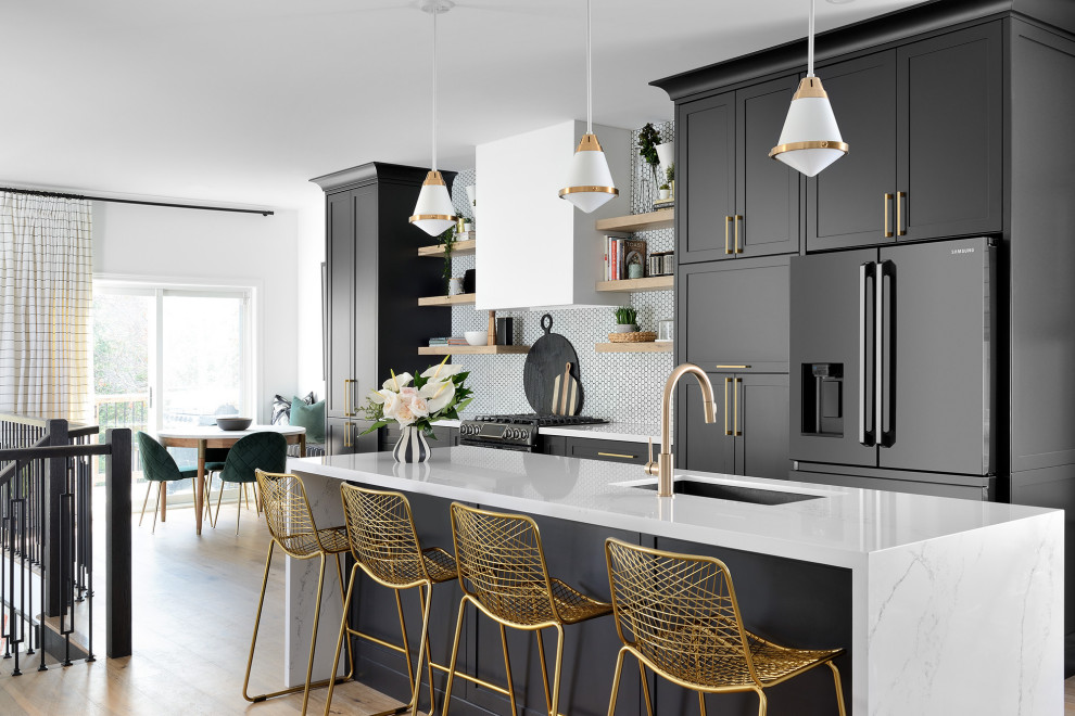 Large transitional galley medium tone wood floor and beige floor eat-in kitchen photo in Toronto with an undermount sink, shaker cabinets, black cabinets, white backsplash, porcelain backsplash, black appliances, an island and white countertops