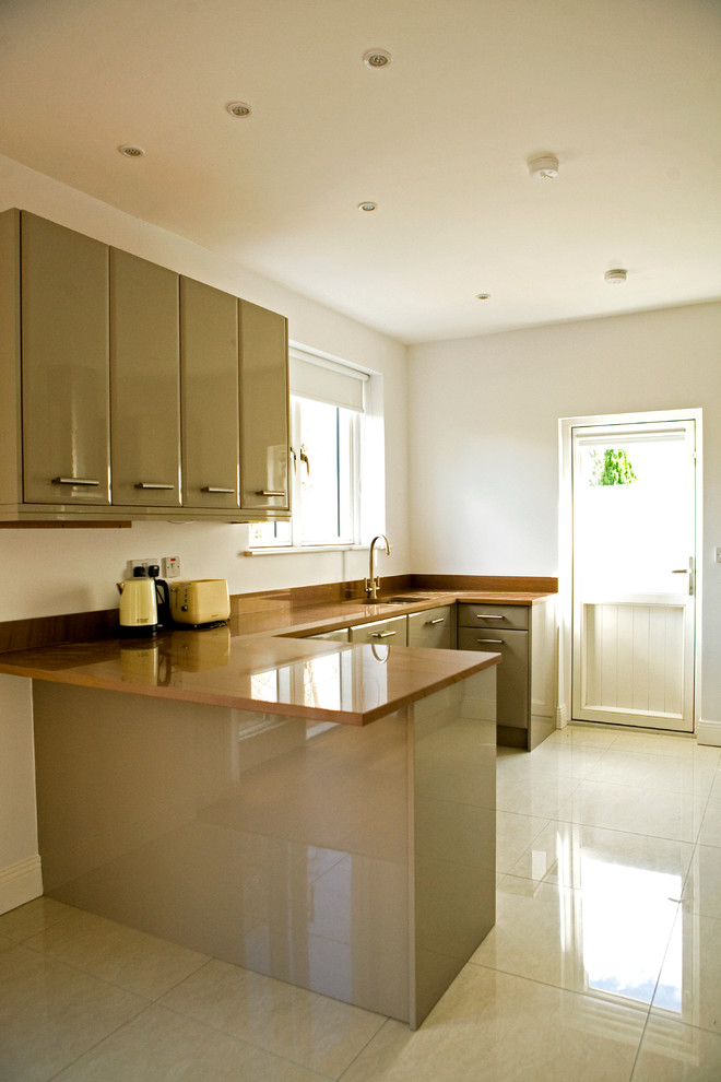 Medium sized contemporary galley kitchen/diner in Dublin with a double-bowl sink, flat-panel cabinets, green cabinets, marble worktops, integrated appliances, porcelain flooring and no island.