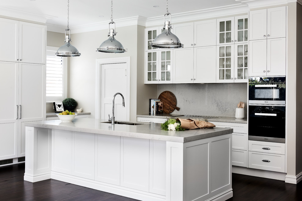 This is an example of a traditional kitchen pantry in Sydney with a double-bowl sink, shaker cabinets, white cabinets, engineered stone countertops, grey splashback, dark hardwood flooring, an island, brown floors and grey worktops.