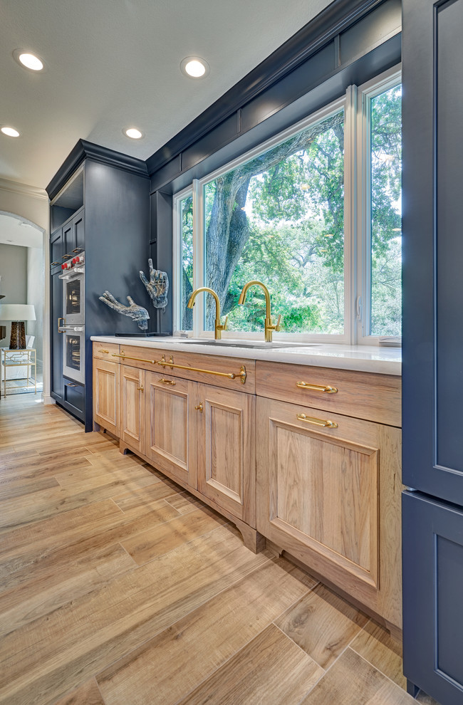 Inspiration for a large traditional l-shaped kitchen/diner in Sacramento with a submerged sink, recessed-panel cabinets, blue cabinets, engineered stone countertops, grey splashback, ceramic splashback, stainless steel appliances, porcelain flooring, an island, beige floors and white worktops.