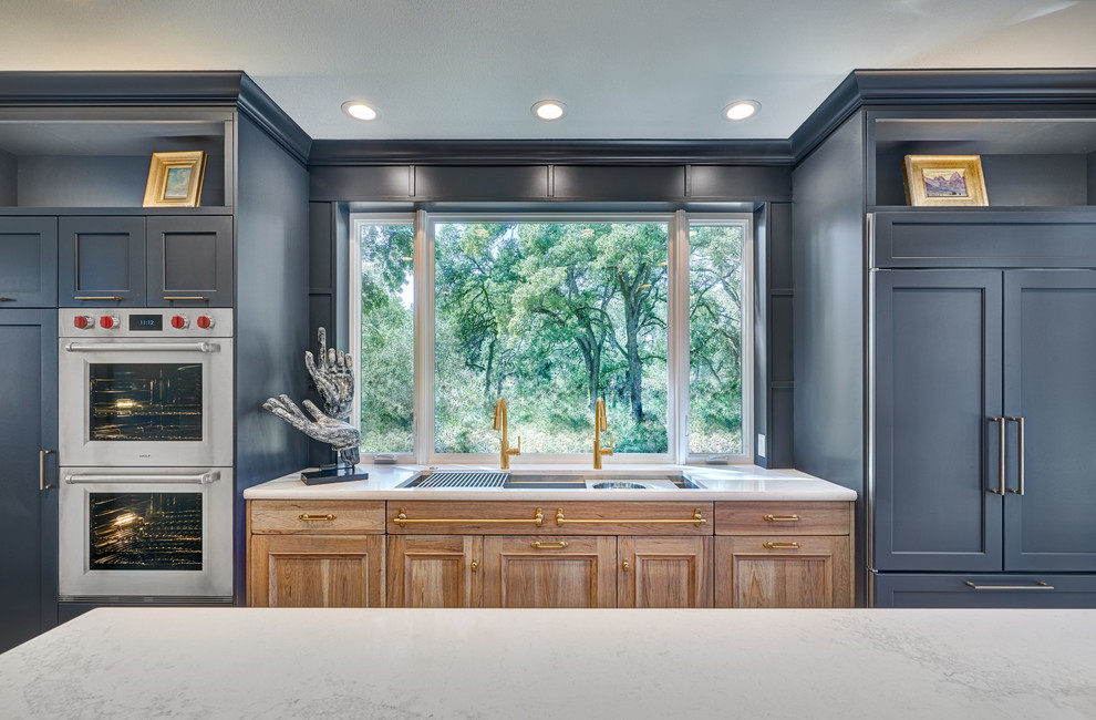 Inspiration for a large transitional l-shaped porcelain tile and beige floor eat-in kitchen remodel in Sacramento with an undermount sink, recessed-panel cabinets, blue cabinets, quartz countertops, gray backsplash, ceramic backsplash, stainless steel appliances, an island and white countertops