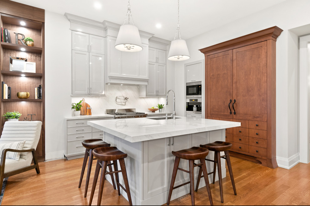 Transitional l-shaped medium tone wood floor and brown floor open concept kitchen photo in Toronto with an undermount sink, beaded inset cabinets, white cabinets, white backsplash, paneled appliances, an island and white countertops