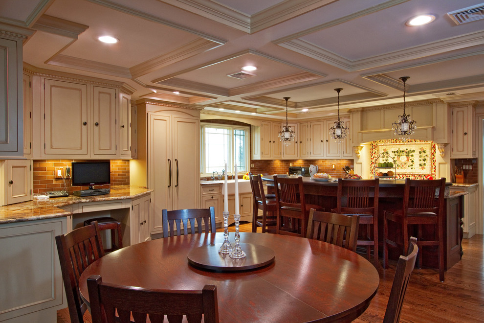 Large elegant u-shaped medium tone wood floor and brown floor eat-in kitchen photo in New York with a farmhouse sink, beaded inset cabinets, beige cabinets, granite countertops, red backsplash, subway tile backsplash, paneled appliances, an island and multicolored countertops