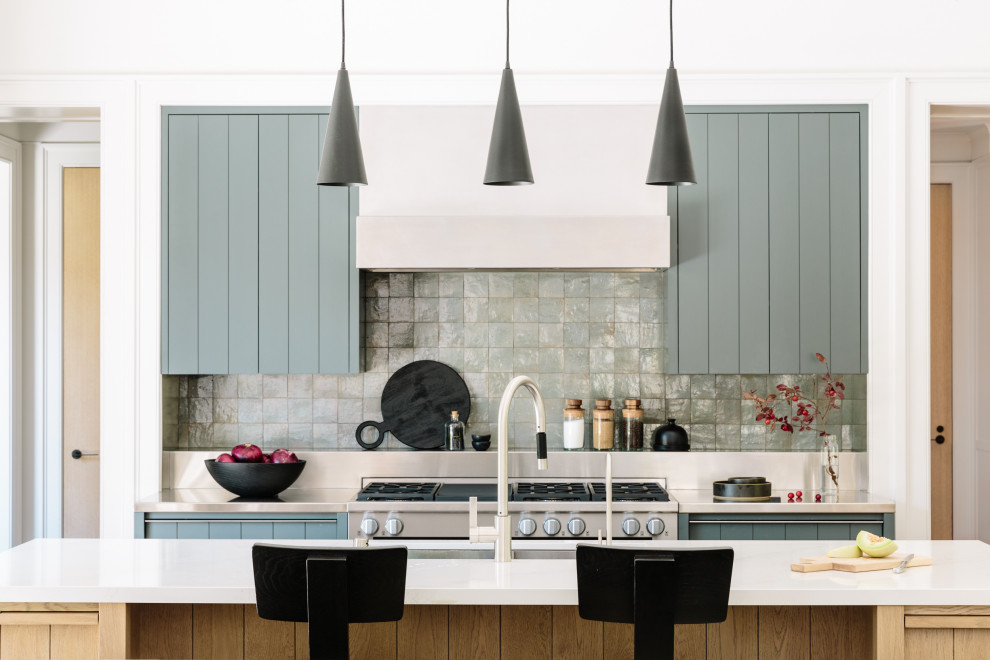 Example of a mid-sized country galley vaulted ceiling eat-in kitchen design in San Francisco with blue cabinets, stainless steel countertops, gray backsplash, stainless steel appliances, gray countertops, flat-panel cabinets, glass tile backsplash, two islands and a double-bowl sink
