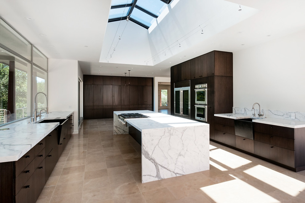 Immagine di una grande cucina moderna chiusa con lavello stile country, ante marroni, top in marmo, elettrodomestici in acciaio inossidabile e ante lisce