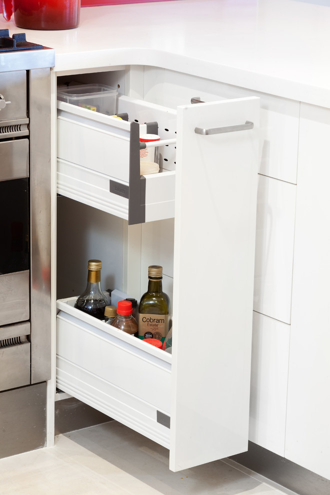 Diseño de cocina moderna con armarios con paneles lisos, puertas de armario blancas, encimera de acrílico y encimeras blancas
