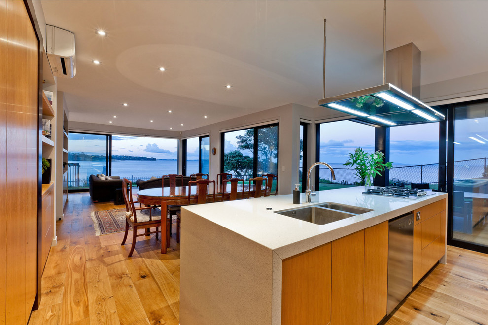 Photo of a large contemporary l-shaped kitchen in Auckland with a built-in sink, beaded cabinets, light wood cabinets, terrazzo worktops, stainless steel appliances, light hardwood flooring and an island.