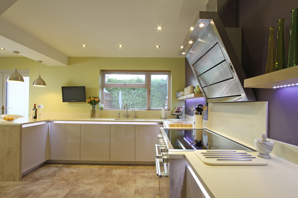 Foto di una cucina moderna di medie dimensioni con lavello a vasca singola, ante lisce, ante bianche, top in superficie solida, paraspruzzi bianco, elettrodomestici colorati e penisola