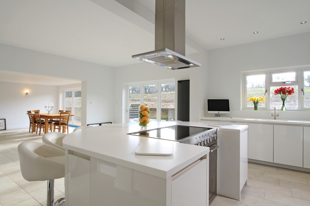 Photo of a large modern l-shaped kitchen/diner in Hampshire with a single-bowl sink, flat-panel cabinets, white cabinets, white appliances, porcelain flooring and an island.
