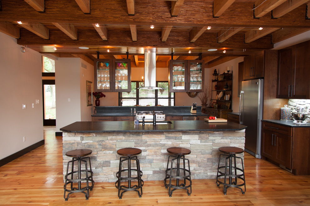 Large mountain style u-shaped medium tone wood floor open concept kitchen photo in St Louis with an undermount sink, shaker cabinets, dark wood cabinets, granite countertops, stainless steel appliances and two islands